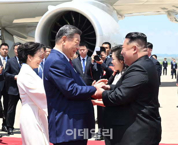 시진핑(왼쪽) 중국 국가주석이 지난 6월 8일 북한 평양 순안공항에 도착해 김정은 북한 국무위원장과 손을 잡고 인사하고 있다. [신화통신=연합뉴스 제공]