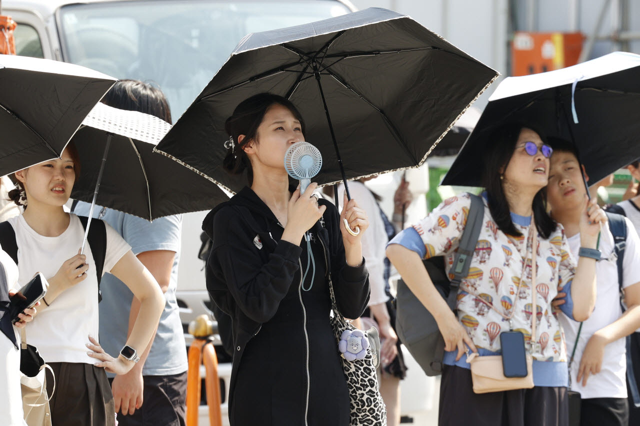 지난 7월 22일 일본 도쿄에서 높은 기온이 이어지는 가운데, 보행자들이 햇빛을 가리기 위해 양산을 쓰고 있다.(사진=연합뉴스)