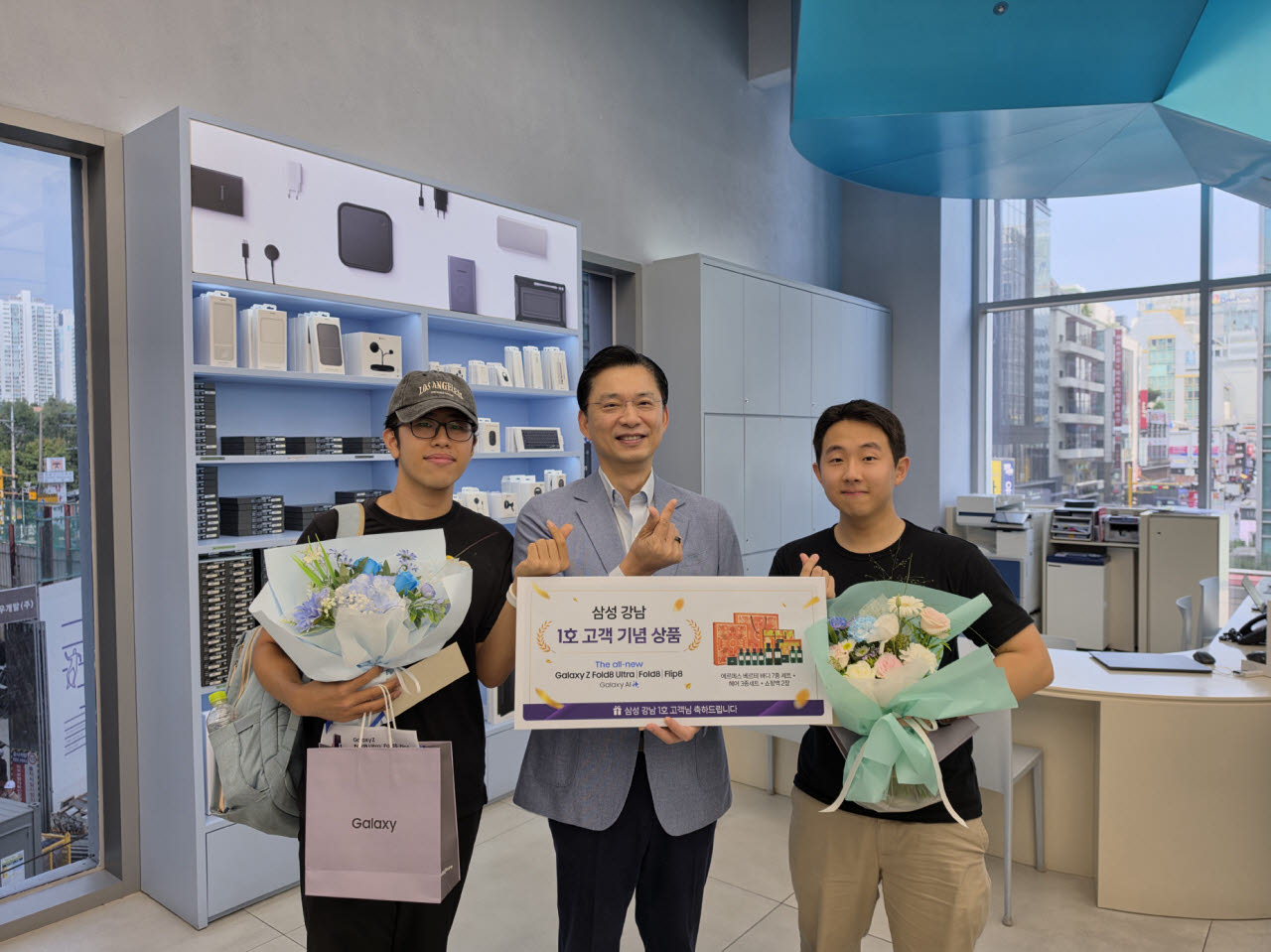 임성택 삼성전자 한국총괄 부사장(가운데)이 삼성 강남에서 진행한 1호 고객 행사에서 고객을 축하하고 있다. (사진=삼성전자)