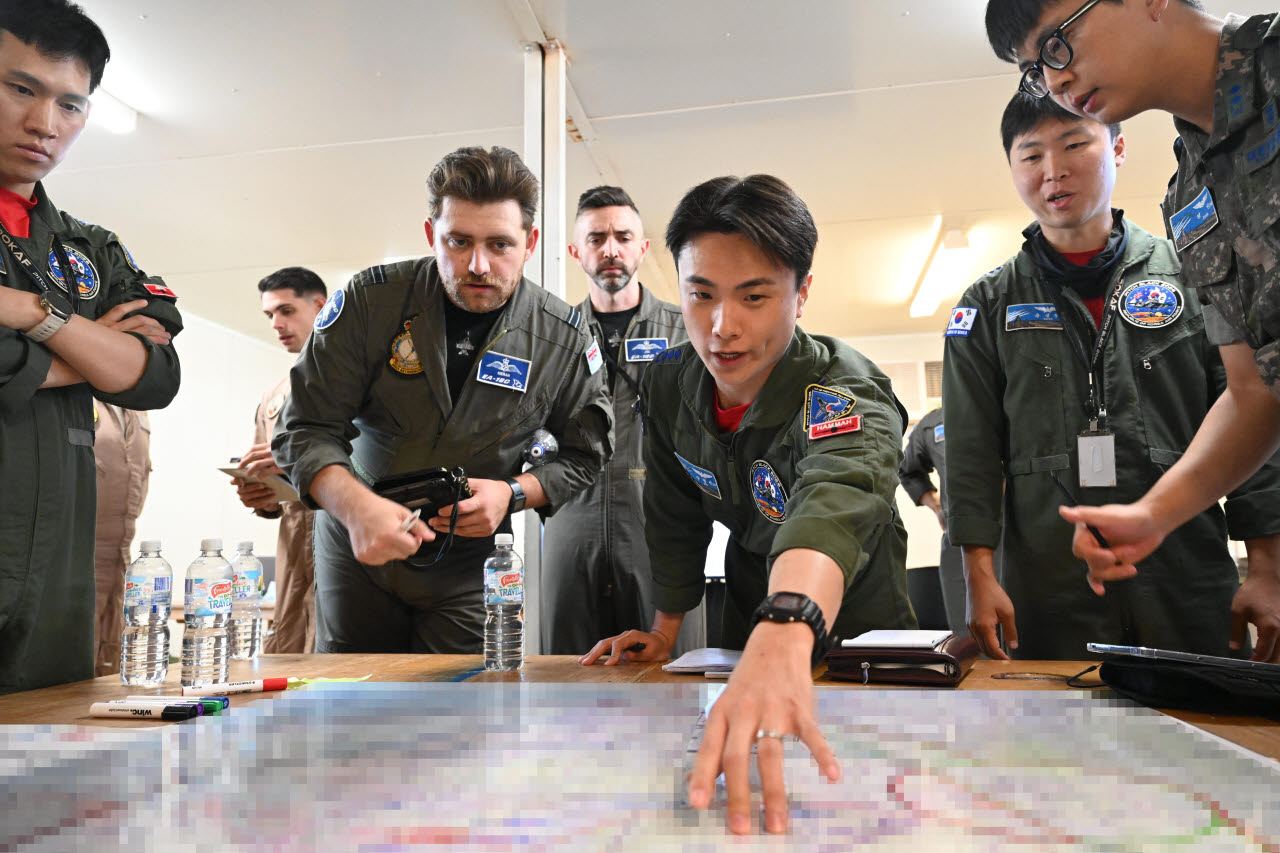 임무지휘관(Mission Commander) 역할을 맡은 나형신 대위가 임무계획반(Mission Planning Cell)에서 타국 조종사들과 임무브리핑을 하고 있다. (사진=공군)