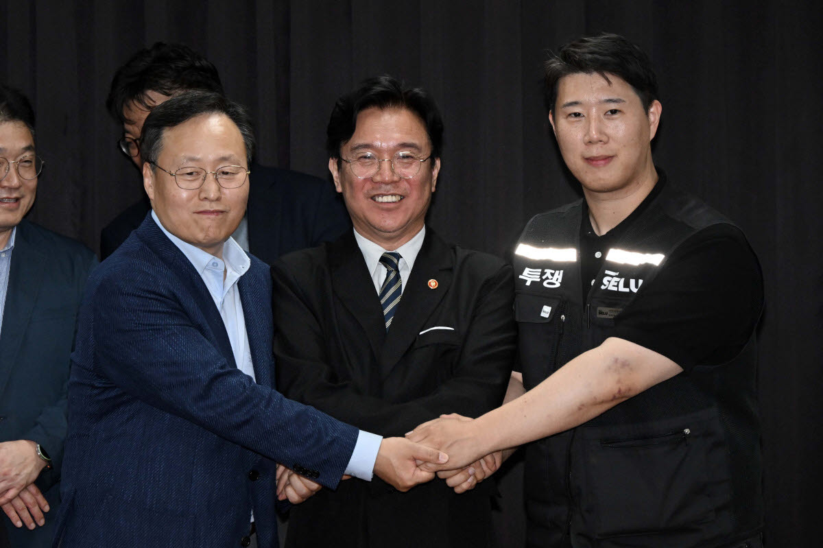 5월 20일 수원시 장안구 경기고용노동청에서 열린 삼성전자 임금협상을 마친 후 여명구 삼성전자 DS(반도체) 부문 피플팀장과 최승호 삼성그룹 초기업노동조합 삼성전자지부 위원장이 잠정 합의안에 서명한 후 김영훈 고용노동부 장관과 기념촬영을 하고 있다. (사진=연합뉴스)