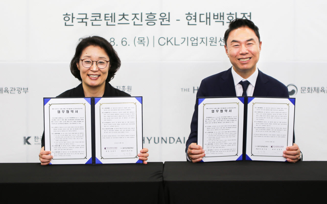 정지영 현대백화점 사장(오른쪽)이 지난 6일 서울 중구 CKL기업지원센터에서 김윤지 한국콘텐츠진흥원장과 패션 디자이너 브랜드 해외 진출 활성화 및 동반성장을 위한 업무협약을 체결한 뒤 기념 촬영하고 있다. (사진=현대백화점)