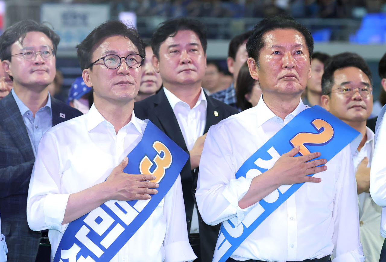 김민석 더불어민주당 당대표 후보와 정청래 후보가 8일 인천 남동체육관에서 열린 더불어민주당 당대표·최고위원 순회경선 합동연설회에서 국기에 경례하고 있다. (사진=연합뉴스)