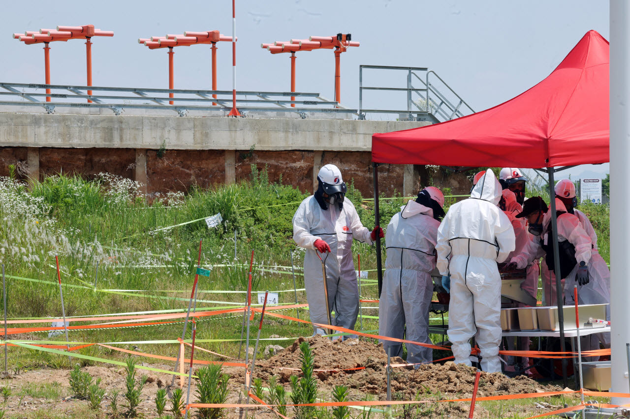 12·29 제주항공 여객기 참사 희생자들의 유해 수색 작업이 재개된 지난 6월 15일 전남 무안군 무안국제공항 사고 현장인 콘크리트 둔덕 부근에서 작업자들이 장비를 이용해 흙을 체에 거르고 있다. (사진=연합뉴스)