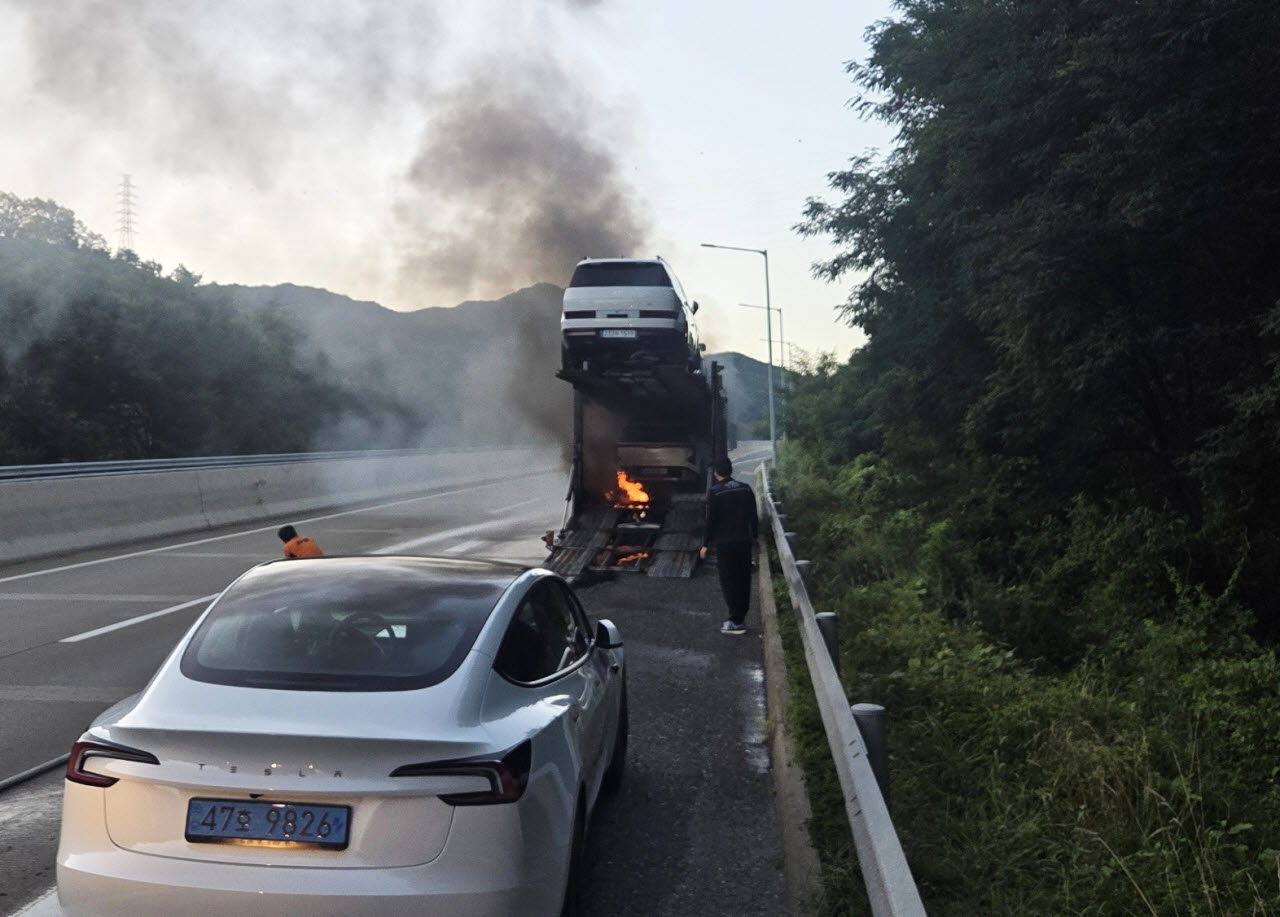 12일 오전 6시20분께 충남 금산군 부리면 통영대전고속도로에서 탁송차 화재가 발생한 것을 목격한 미추홀소방서 주안119안전센터 소속 심광보·임홍택 소방위가 진화작업을 하고 있다. (사진 = 인천소방본부 제공)