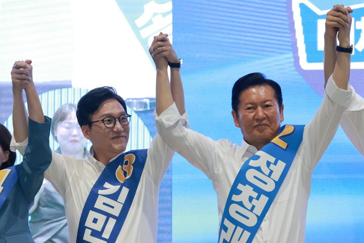 더불어민주당 김민석· 정청래 당 대표 후보가 9일 강원도 횡성국민체육센터에서 열린 민주당 대표·최고위원 후보자 강원 합동연설회에서 손을 잡고 기념 촬영하고 있다. (사진=연합뉴스)