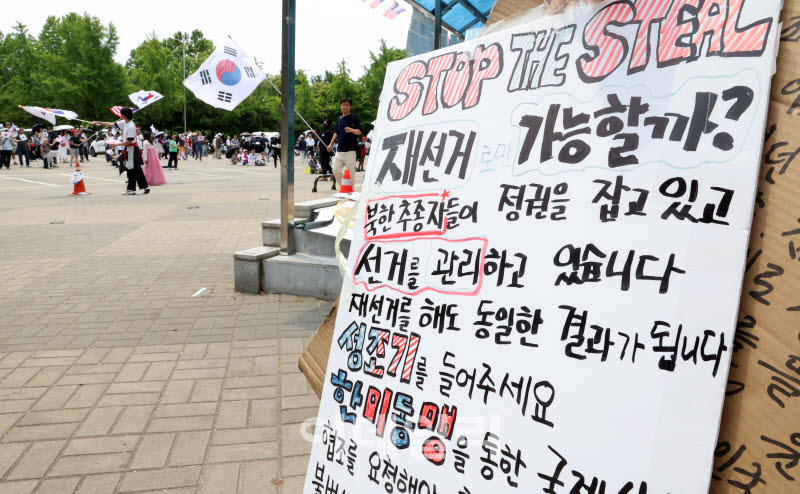 6·3 지방선거 투표용지 부족 사태를 규탄하는 개표소 봉쇄 시위가 이어지고 있는 지난 14일 서울 송파구 올림픽공원 핸드볼경기장 일대에서 시위참가자들이 구호를 외치며 태극기를 흔들고 있다. (사진= 방인권 기자)