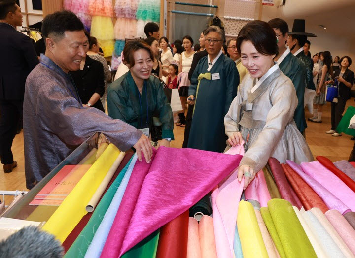 김혜경 여사가 14일 서울 중구 동대문디자인플라자에서 열린 한복박람회 '2026 한복상점'에서 원단을 보고 있다.(사진=연합뉴스)
