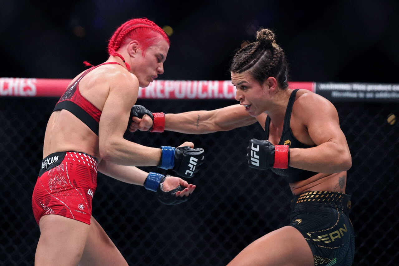UFC 여성 스트로급 챔피언 맥켄지 던(오른쪽)이 도전자 질리언 로버트슨에게 펀치를 적중시키고 있다. 사진=AFPBBNews