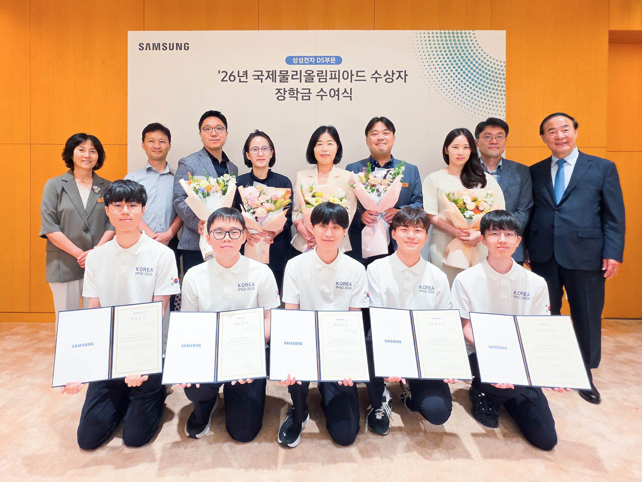 전영현 삼성전자 DS 부문장(부회장, 뒷줄 오른쪽)과 윤진희 한국물리학회장(뒷줄 왼쪽), 올해 국제물리올림피아드 수상자들(앞줄 전원)과 학부모 등이 지난 13일 삼성전자 화성캠퍼스에서 열린 장학금 수여식에 참석해 기념촬영하고 있다. (사진=삼성전자)