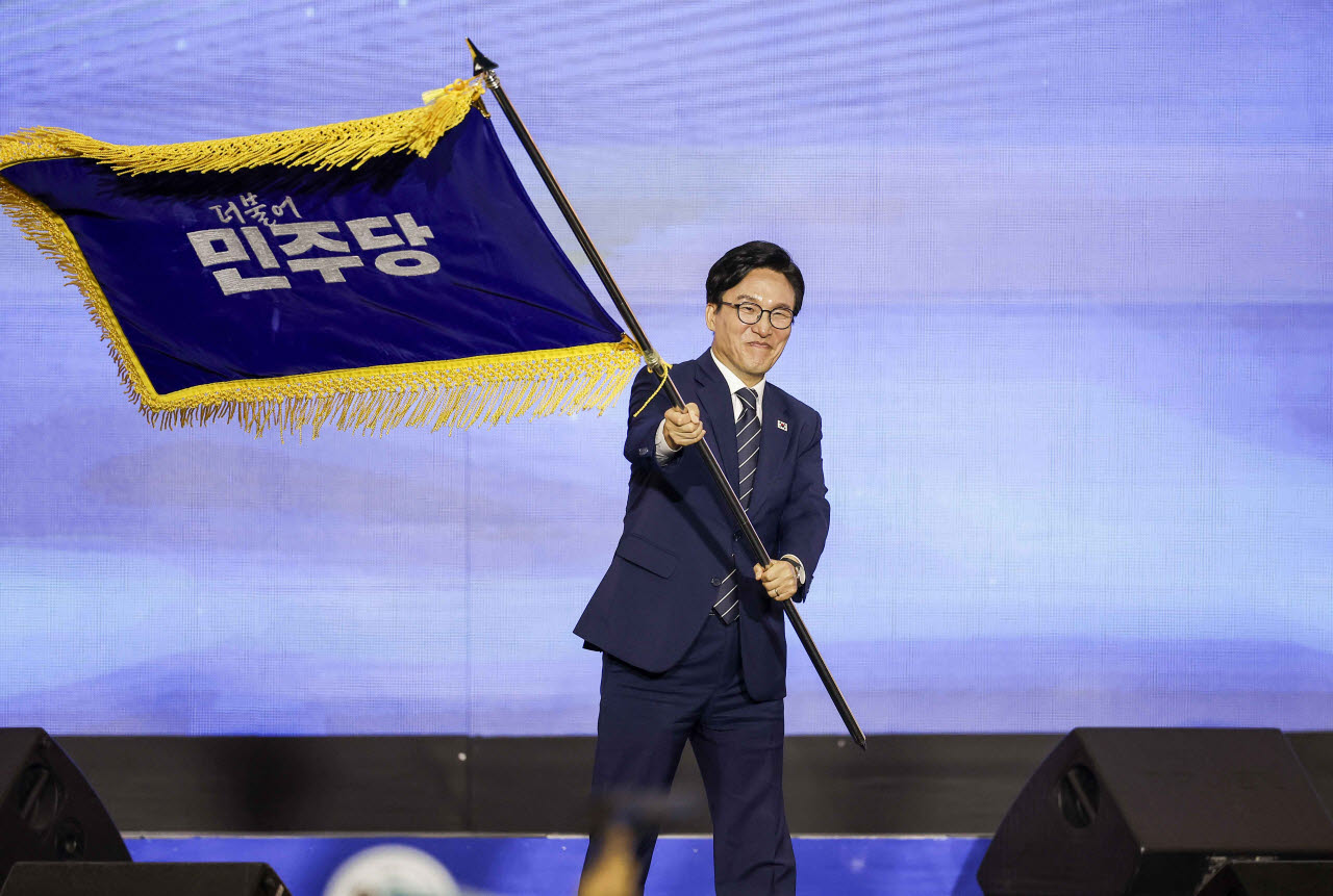 김민석 신임 더불어민주당 당대표가 17일 대전 유성구 대전컨벤션센터 제2전시장에서 열린 더불어민주당 제3차 정기전국당원대회에서 당기를 흔들고 있다. 사진=뉴시스
