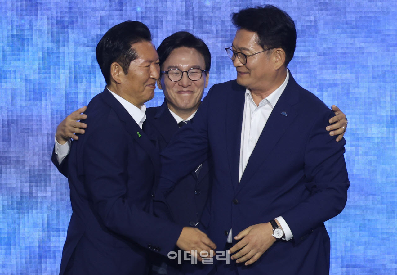 김민석 더불어민주당 신임 당대표가 17일 대전시 유성구 대전컨벤션센터에서 열린 더불어민주당 제3차 정기전국당원대회에서 정청래, 송영길 후보의 등을 토닥이고 있다. (사진=이영훈 기자)
