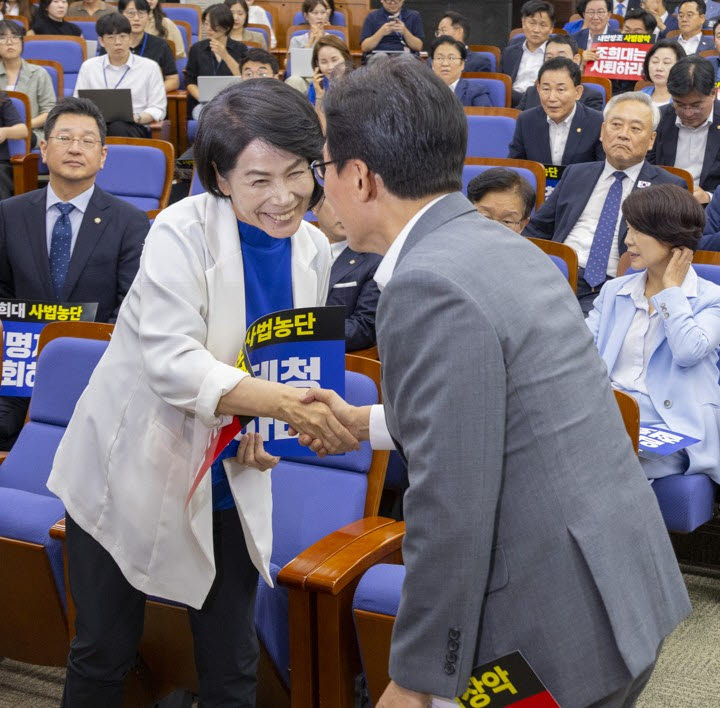 더불어민주당 최민희 최고위원(왼쪽)이 20일 국회에서 전당대회 뒤 처음으로 열린 의원 총회에서 김민석 대표와 악수하고 있다. (사진=연합뉴스)