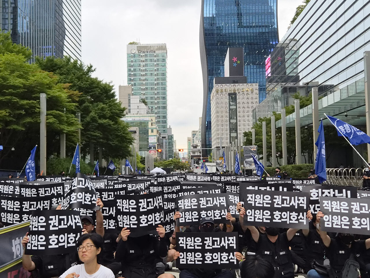 삼성전자 동행노조 조합원들이 21일 서울 서초구 삼성전자 서초사옥 앞에서 ‘직원은 권고사직, 임원은 호의호식’이라고 적힌 피켓을 들고 집회에 참여하고 있다. (사진=송재민 기자)