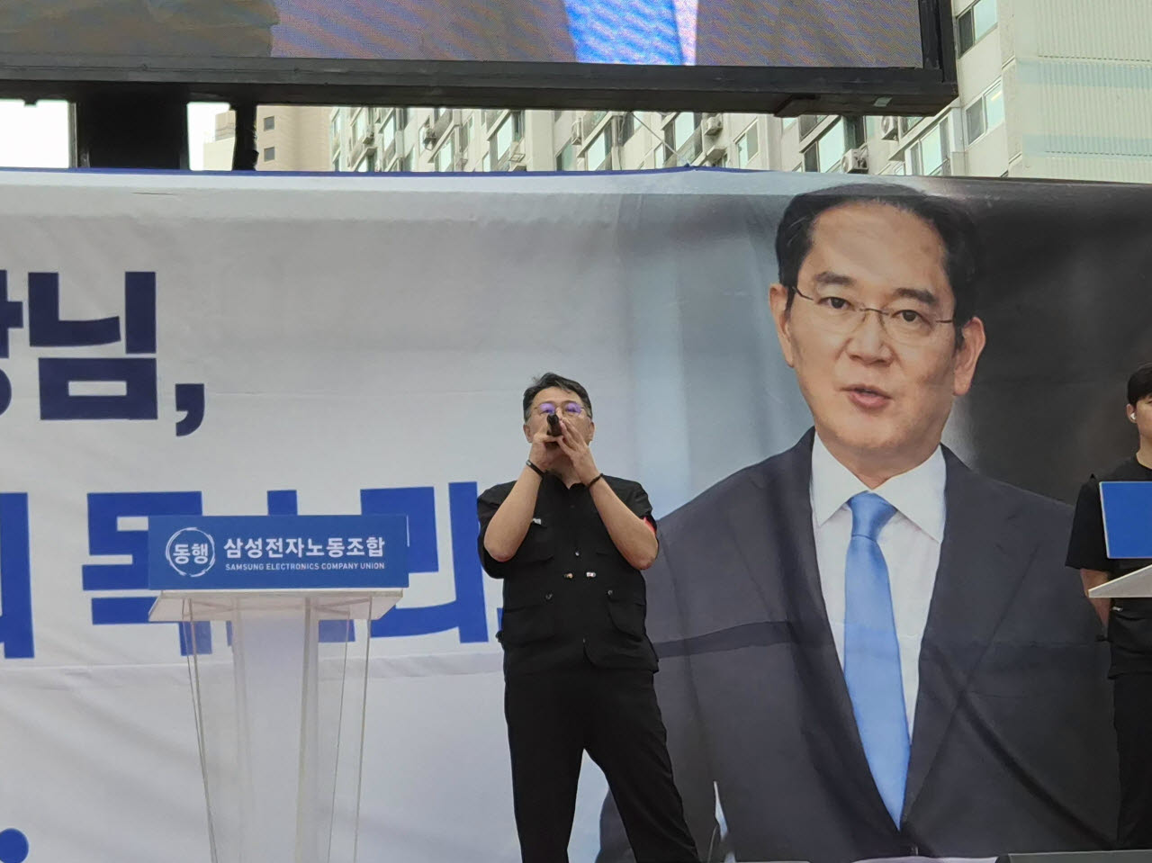 구성환 삼성전자 동행노조 사무국장이 21일 서울 서초구 삼성전자 서초사옥 인근에서 열린 집회에서 이재용 삼성전자 회장의 사진을 배경으로 발언하고 있다. (사진=송재민 기자)