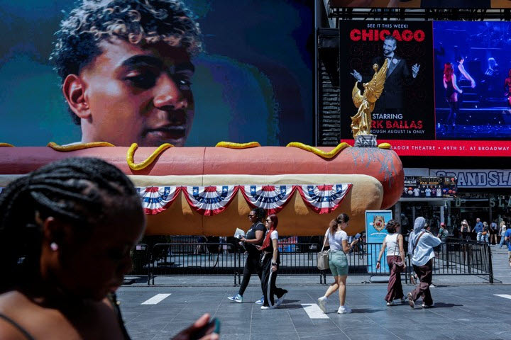 지난 7일(현지시간) 미국 뉴욕 타임스스퀘어에서 시민들이 ‘핫도그 인 더 시티(Hot Dog in the City)’ 설치미술 작품 앞을 지나고 있다. (사진=로이터)