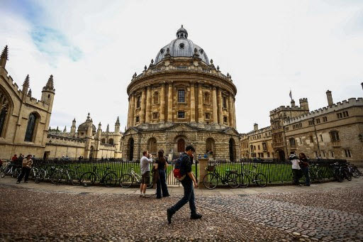 This photo taken on June 17, 2026 shows people walking past the Radcliffe Camera building at Oxford University in Oxford, central England. With its grand atrium, 500-seat acoustics-led concert hall and other state-of-the-art spaces, Oxford's Schwarzman Centre is the newest example of an elite UK university showcasing a billionaire's endowment. (Photo by HENRY NICHOLLS / AFP) / TO GO WITH Britain-education-universities-philanthrophy,FOCUS by Joe JACKSON