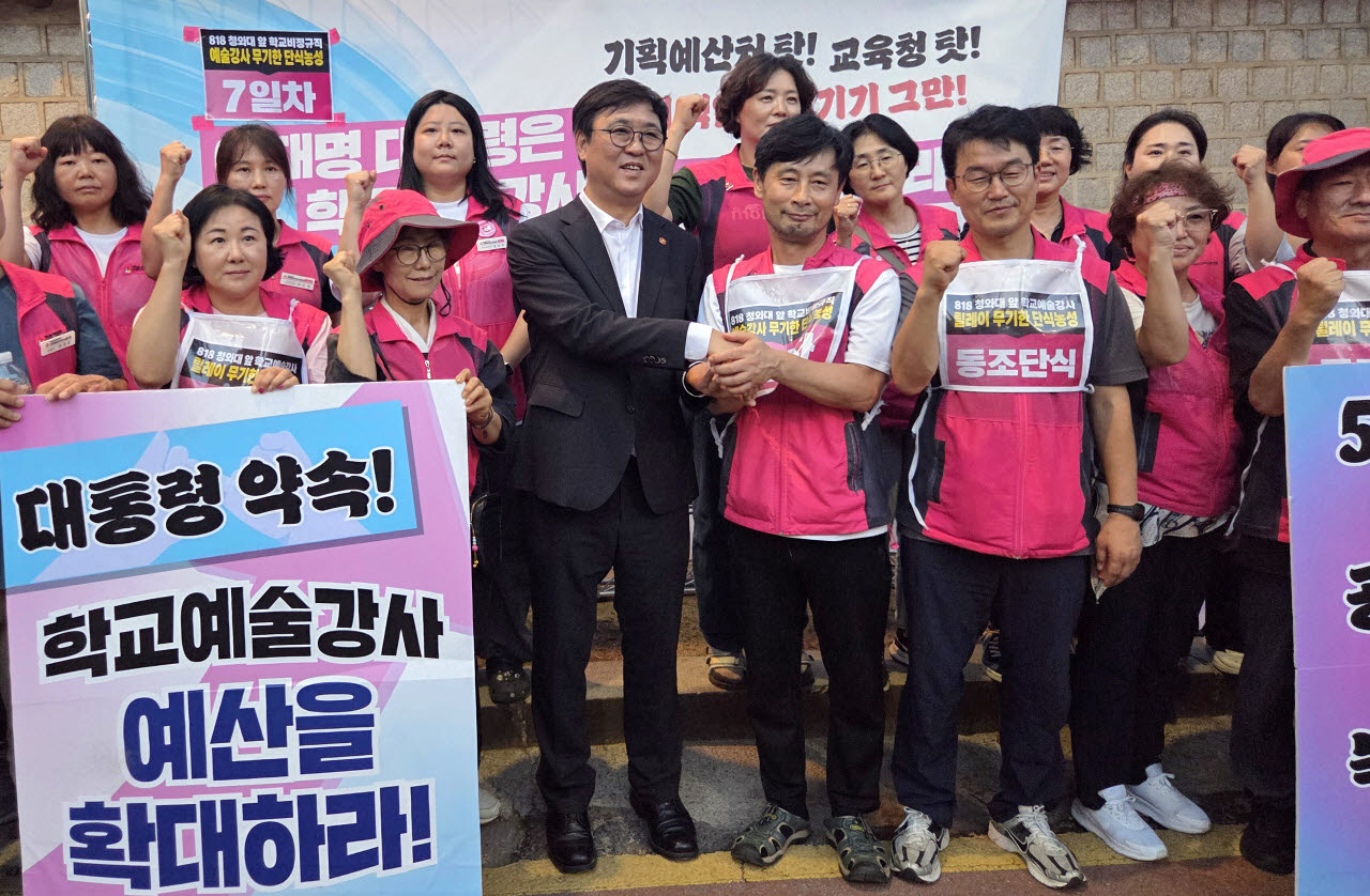 최휘영 문화체육관광부 장관이 24일 서울 청와대 사랑채 인근에서 학교예술강사지원사업 예산 증액을 요구하며 단식농성 중인 전국학교비정규직노동조합 성석주 예술강사전국분과장을 만나 단식 중단을 요청하며 손을 맞잡고 있다(사진=연합뉴스).