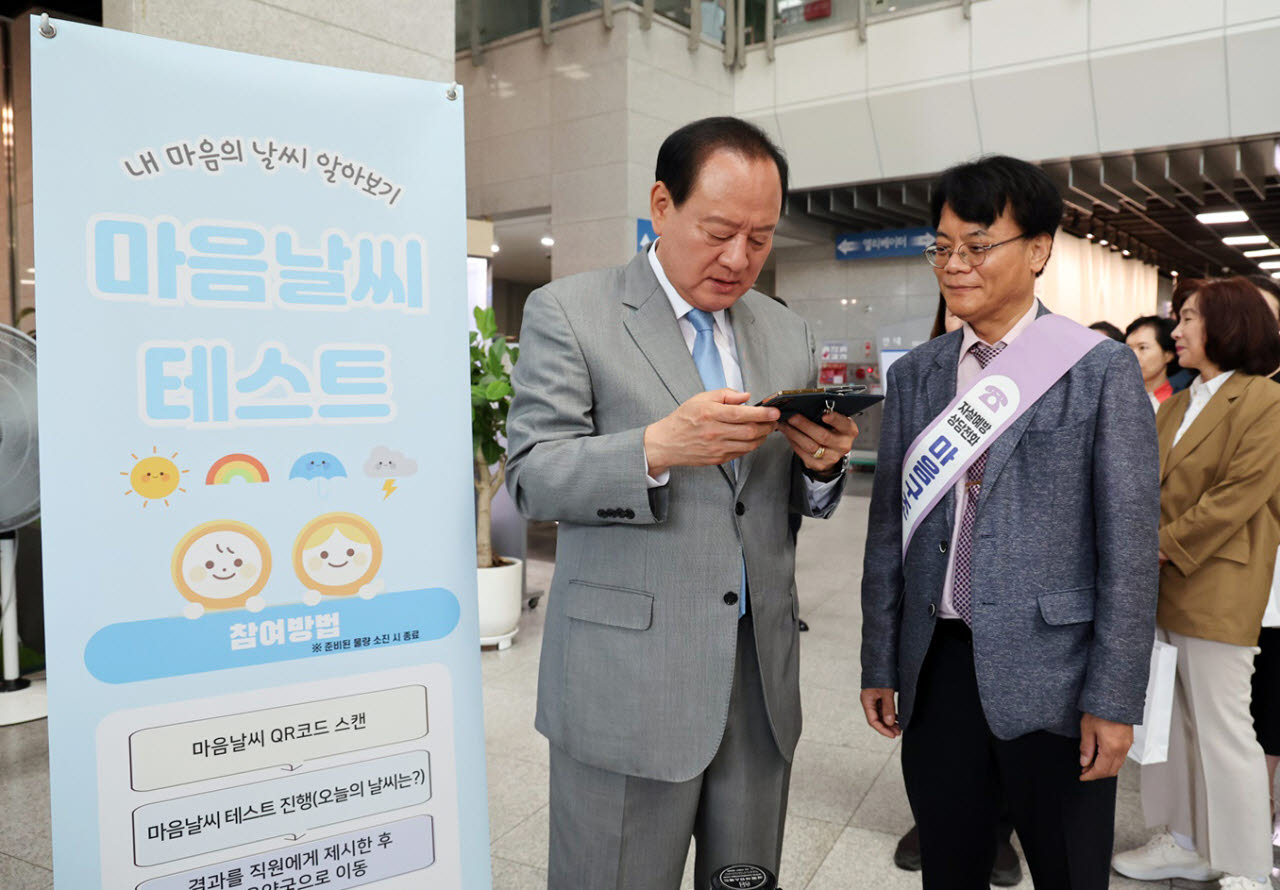 유동균 마포구청장이 25일 ‘2026년 마음날씨 오프라인 행사’에 참석해 QR코드를 활용한 마음건강 셀프 체크에 참여하고 있다. (사진=마포구)