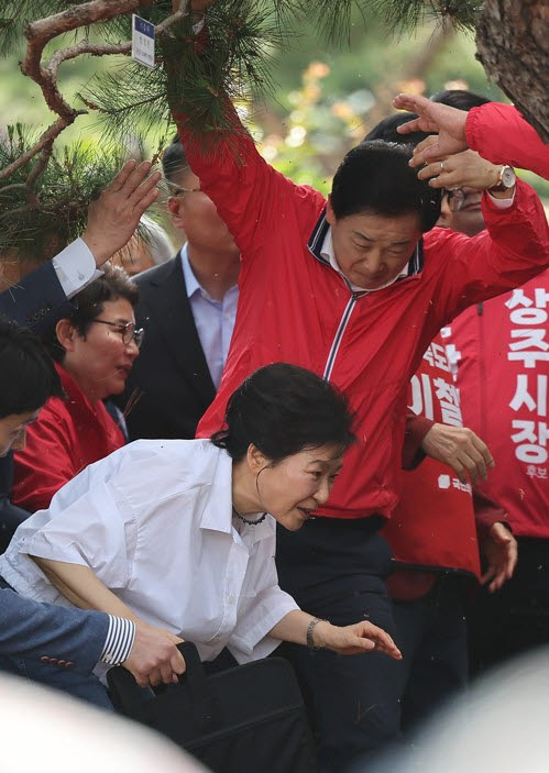박근혜 전 대통령이 지난 5월 28일 경북 문경시 청운각을 방문해 이동할 때 국민의힘 유영하 의원이 소나무 가지를 들어올리며 길을 트고 있다. (사진=연합뉴스)