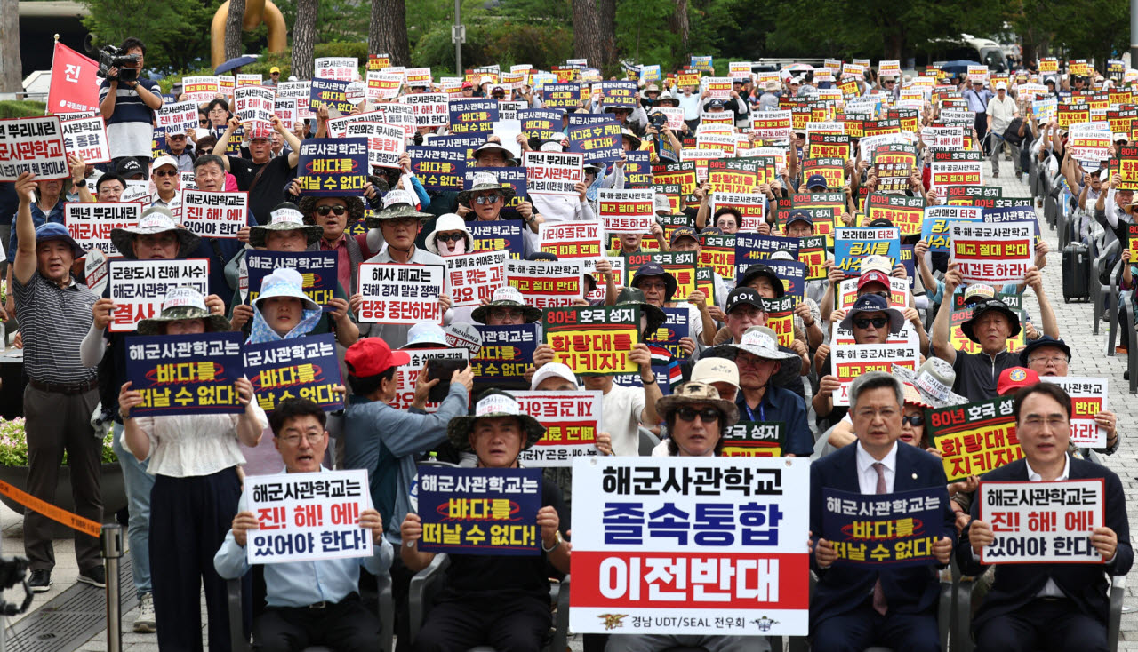 육·해·공 사관학교 통합형인 '국군사관학교' 창설 관련 공청회가 열린 26일 오후 서울 용산구 전쟁기념관 앞에서 열린 육·해·공 사관학교 통폐합 반대 집회에서 참석자들이 사관학교 통폐합에 반대하는 손팻말을 들고 구호를 외치고 있다. (사진=뉴스1)