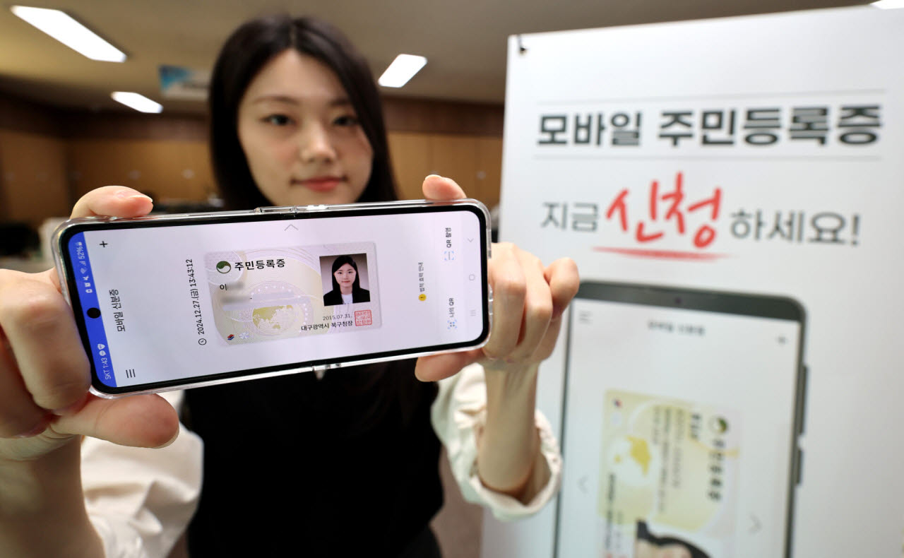 한 여성이 모바일 신분증 화면이 담긴 스마트폰을 들고 있다.(사진=뉴시스)