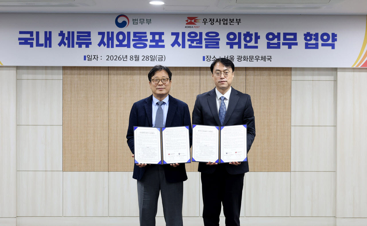 박인환 우정사업본부장(왼쪽)이 28일 차용호 법무부 출입국·외국인정책본부장과 국내 거주 재외동포의 안정적인 정착 지원을 위한 업무협약을 체결하고 있다. (사진=우정사업본부)