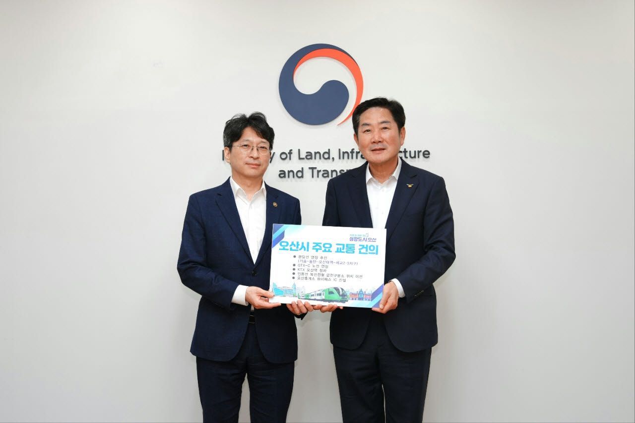 조용호 오산시장(오른쪽)이 28일 서울 국토발전전시관에서 홍지선 국토부 제2차관에게 오산시 주요 교통 현안에 대한 협조를 구하는 건의문을 전달하고 있다.(사진=오산시)