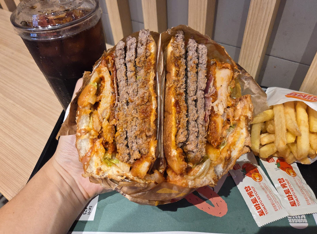 반으로 자른 버거킹 ‘몬스터 맥시멈3’. 직화 비프 패티 3장과 통닭다리살 치킨 패티 등 속재료가 한눈에 드러난다. (사진=한전진 기자)