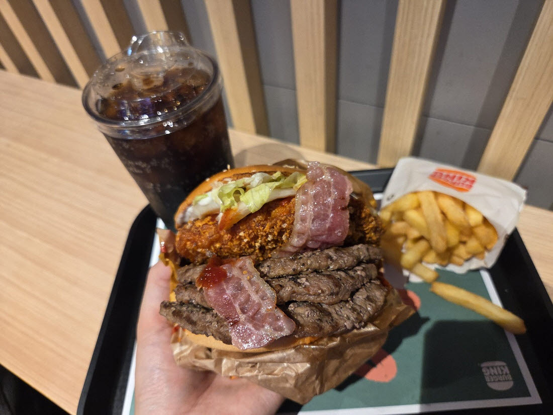버거킹 ‘몬스터 맥시멈3’ 라지세트. 직화 비프 패티 3장과 통닭다리살 치킨 패티, 베이컨 등이 겹겹이 쌓여 있다. (사진=한전진 기자)