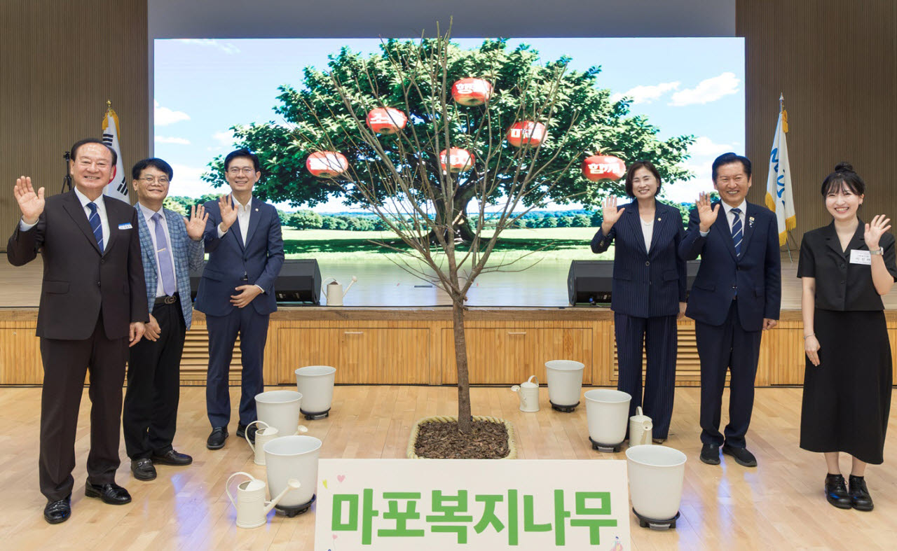 유동균(왼쪽) 마포구청장이 1일 마포중앙도서관에서 열린 ‘2026년 마포구 사회복지대회’에서 주요 참석자들과 ‘마포복지나무’ 기념 퍼포먼스를 하고 있다. (사진=마포구)