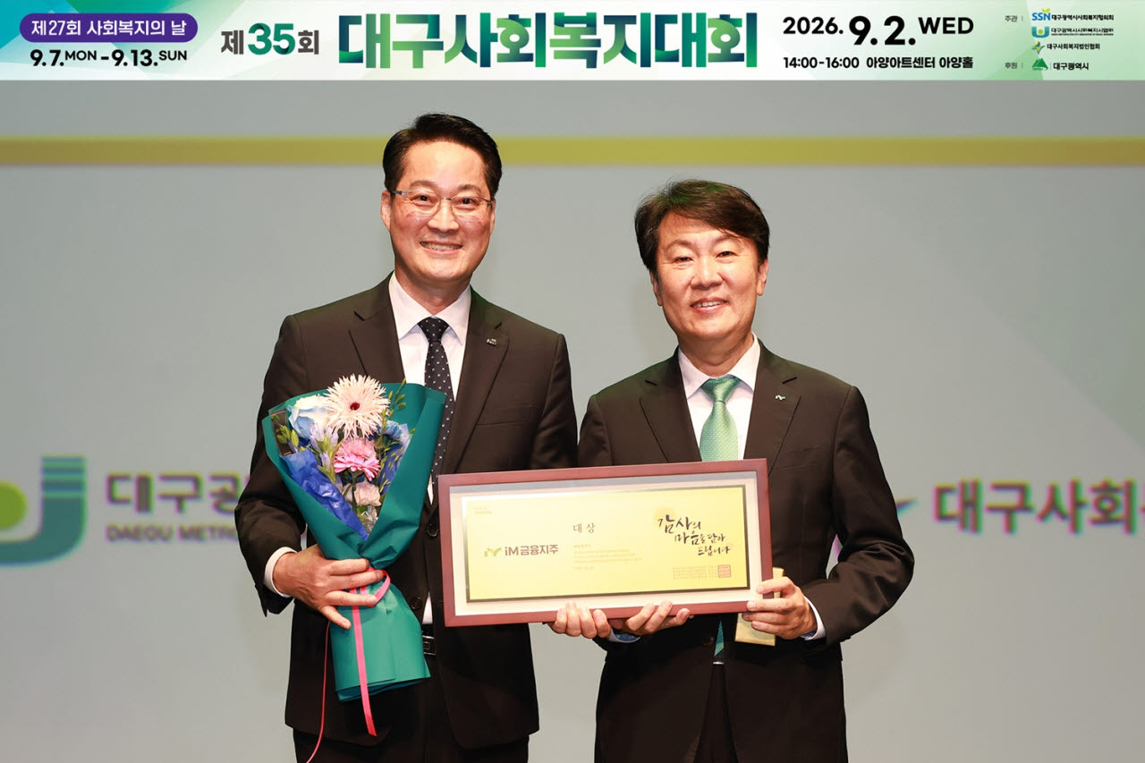 대구사회복지협의회 김석표(왼쪽) 회장과 iM금융지주 그룹가치경영총괄 신용필 전무가 기념식에서 사회공헌 부분 대상을 수상한 후 기념 촬영을 하고 있다.(사진=iM금융)