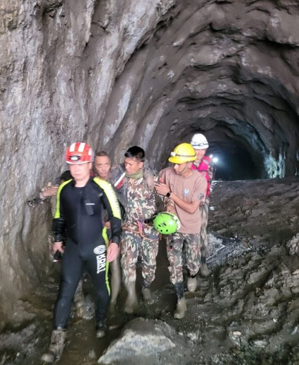 네팔·중국 국경 히말라야 산악지대를 휩쓴 대홍수 발생 열흘 만인 5일(현지시간) 어퍼트리슐리(UT)-1 수력발전소 공사 현장 터널에서 네팔·한국 합동구조대가 중국인 1명을 구조하고 있다. [한국 해외긴급구호대(KDRT) 제공]