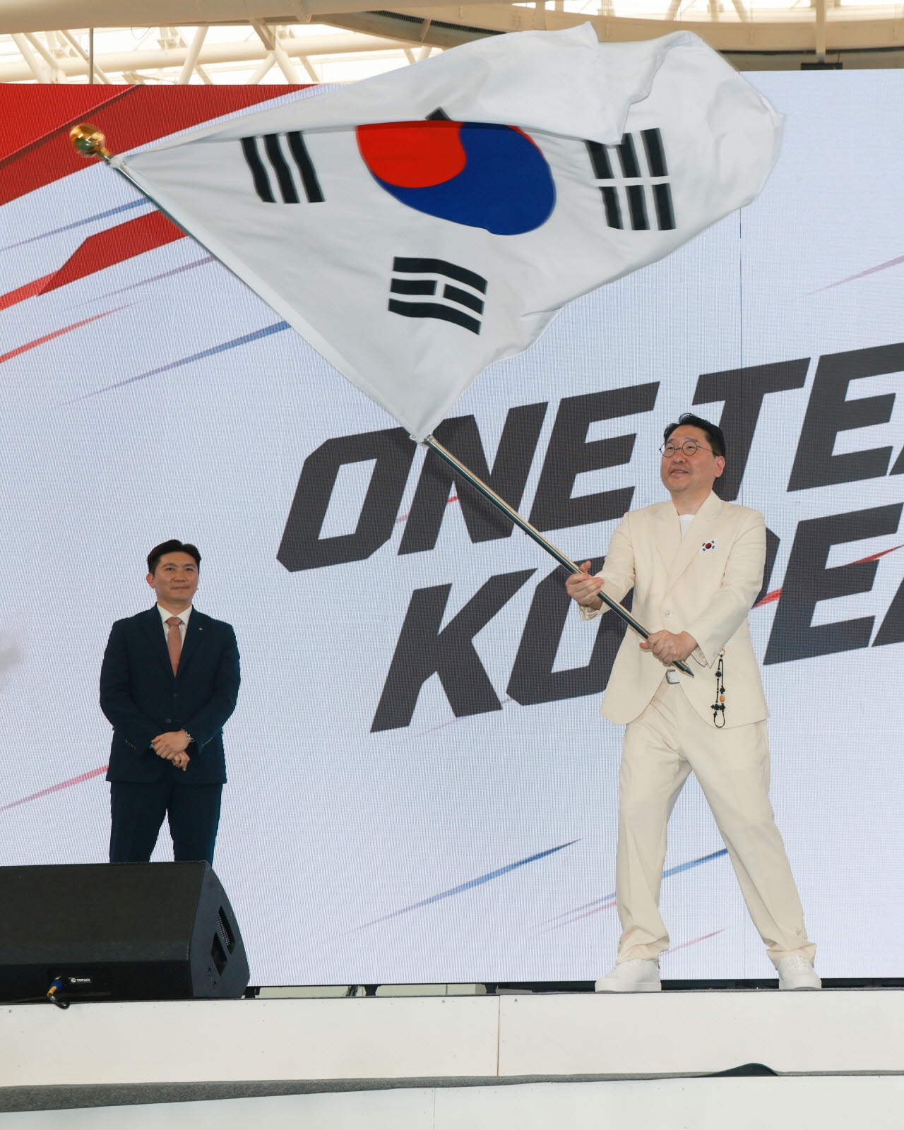 이상현 2026 아이치·나고야 아시안게임 선수단장이 3일 충북 진천선수촌에서 열린 결단식에서 유승민 대한체육회장으로부터 단기를 받아 흔들고 있다. 사진=연합뉴스