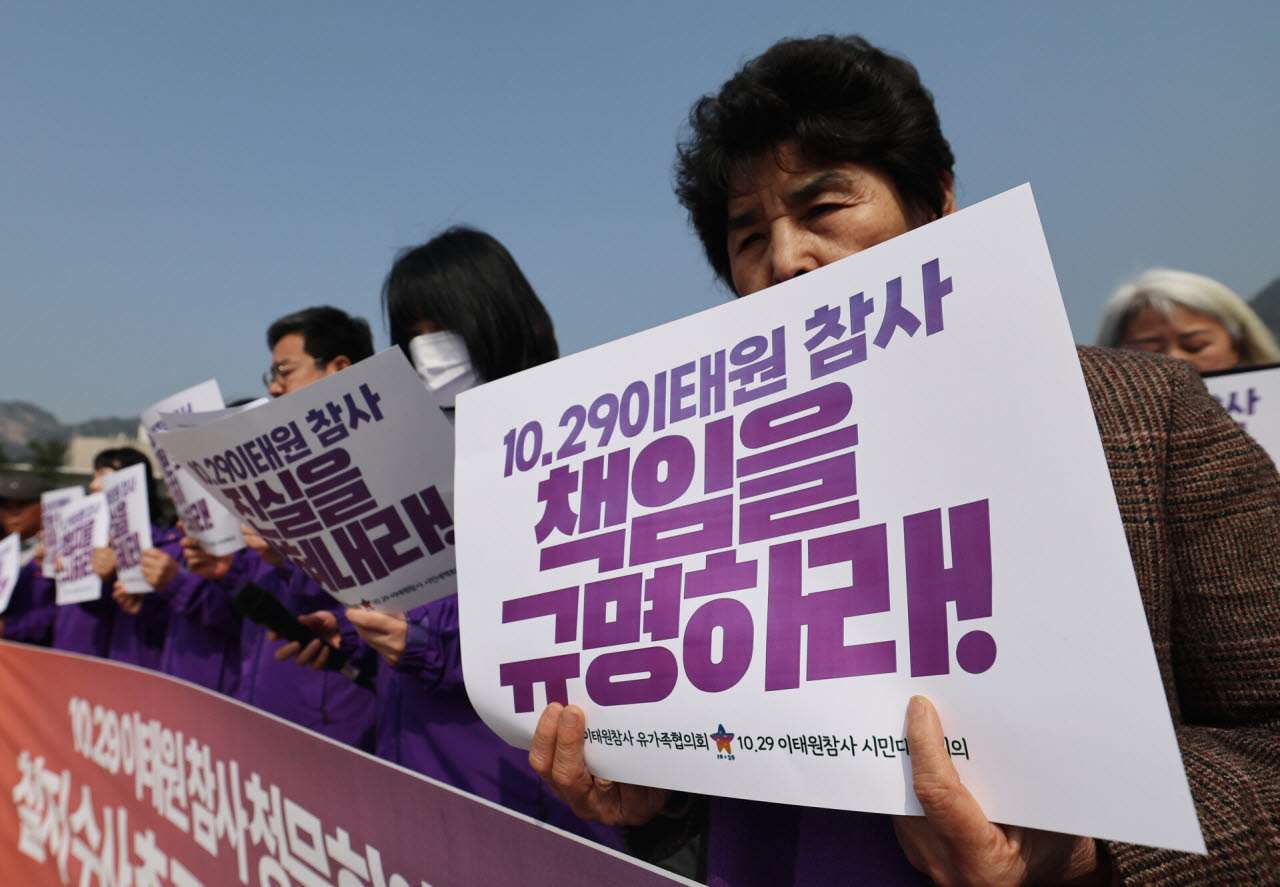 10.29이태원참사 유가족들이 지난 3월 서울 종로구 청와대 분수대 앞에서 열린 '이태원참사 청문회 제기 의혹 철저 수사 촉구 기자회견'에서 침통한 얼굴로 피켓을 들고 있다.(사진=뉴스1)
