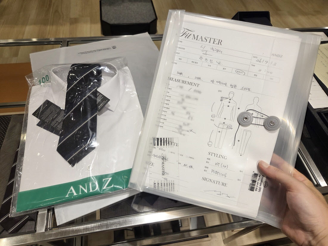 앤드지 핏마스터 체험 후 받은 체촌 결과지와 셔츠·넥타이. 채촌 결과지에는 신체 치수와 체형 특성 등이 기록된다. (사진=한전진 기자)