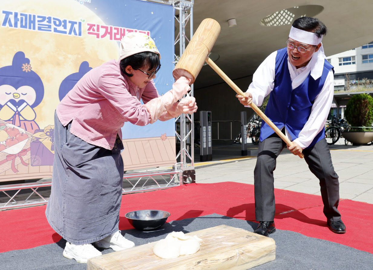 진교훈(오른쪽) 강서구청장이 8일 마곡광장 일대에서 열린 ‘추석맞이 자매결연지 직거래장터’를 찾아 떡메를 치고 있다. (사진=강서구)