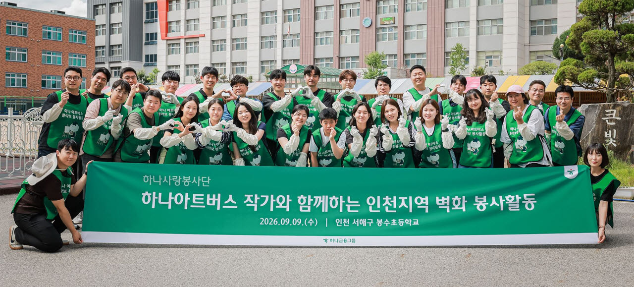 하나금융그룹은 지난 9일 인천 서해구 소재 봉수초등학교에서 그룹의 발달장애인 미술 공모전 ‘하나 아트버스’ 수상 작가와 그룹 임직원 30여 명이 함께 통학로 벽화 조성 봉사활동을 실시했다. 이날 봉사활동에 참여한 하나금융그룹 임직원들이 발달장애인 예술가 이도원 작가(사진 앞줄 가운데)와 함께 기념촬영을 하고 있다.(사진=하나금융그룹)