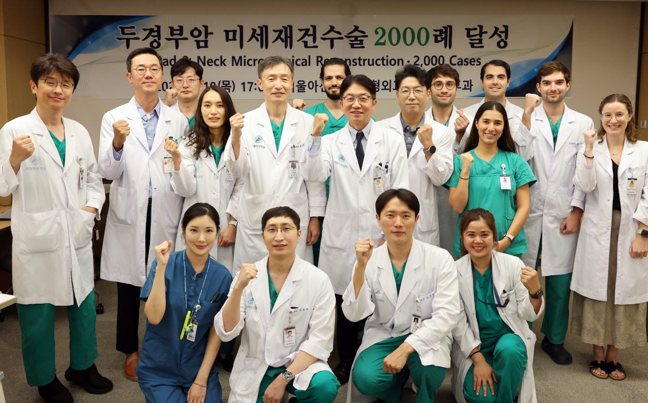 서울아산병원 이비인후과 최승호, 성형외과 최종우 교수(뒷줄 왼쪽 네 번째, 다섯 번째)를 비롯한 의료진이 10일 열린 두경부암 미세재건수술 2,000례 달성 기념식에서 기념촬영을 하고 있다.