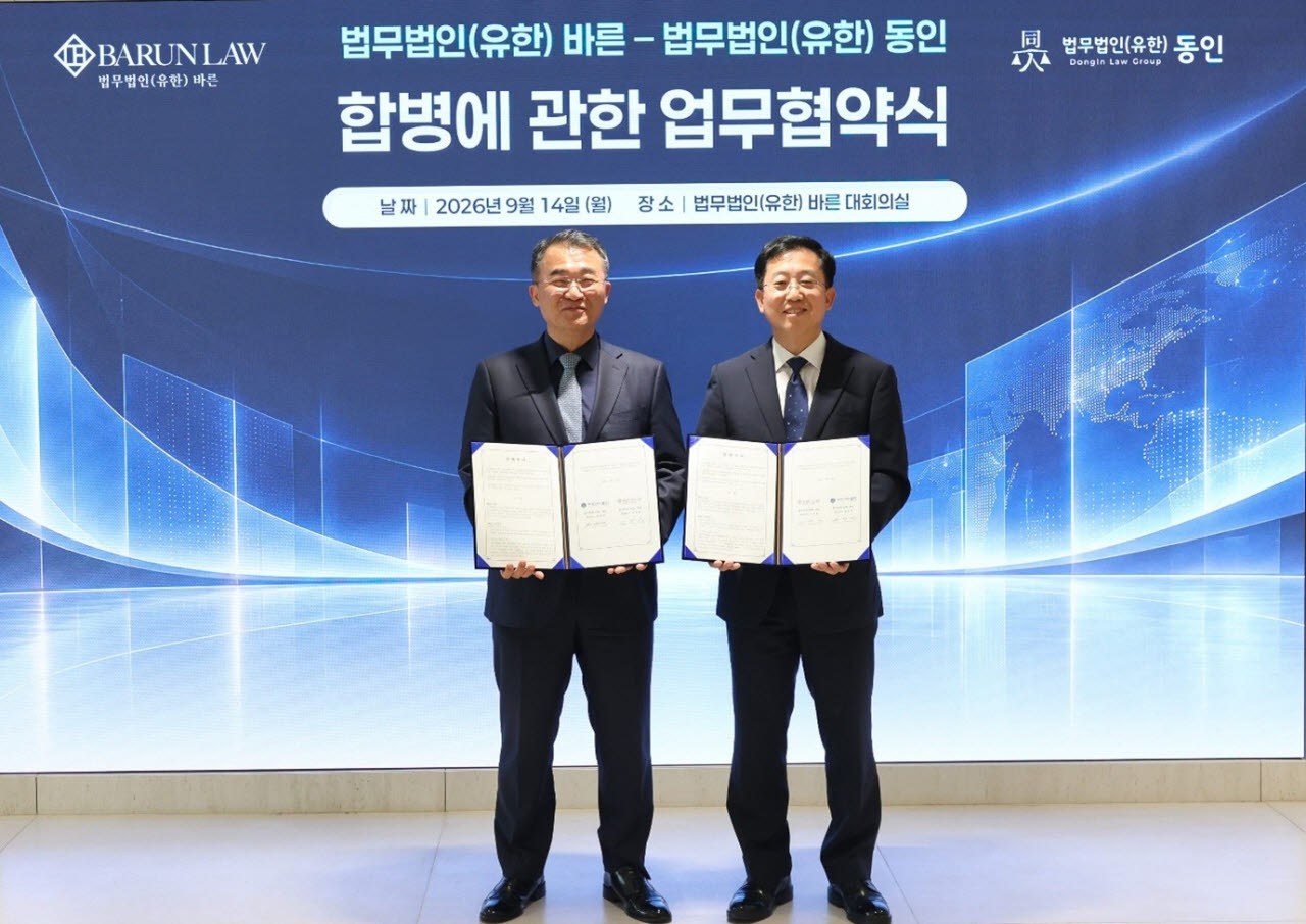 이동훈 바른 대표변호사(오른쪽)와 원창연 동인 대표변호사가 14일 합병추진 업무협약서를 들고 기념사진을 촬영하고 있다. (사진=법무법인 바른)