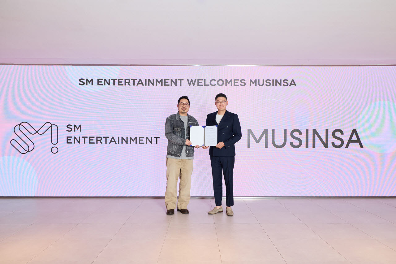 탁영준 SM엔터테인먼트 공동대표(오른쪽)와 최재영 무신사 CCO(최고 커머스 책임자)가 14일 서울 성수동 SM본사에서 업무협약식을 마친 뒤 기념 촬영을 하고 있다. (사진=SM엔터테인먼트)