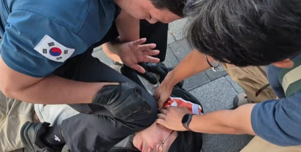 서울 용산경찰서 소속 경찰관이 지난 3일 김남규 활동가를 제압하는 모습(사진= 비정규직이제그만공동투쟁 제공)