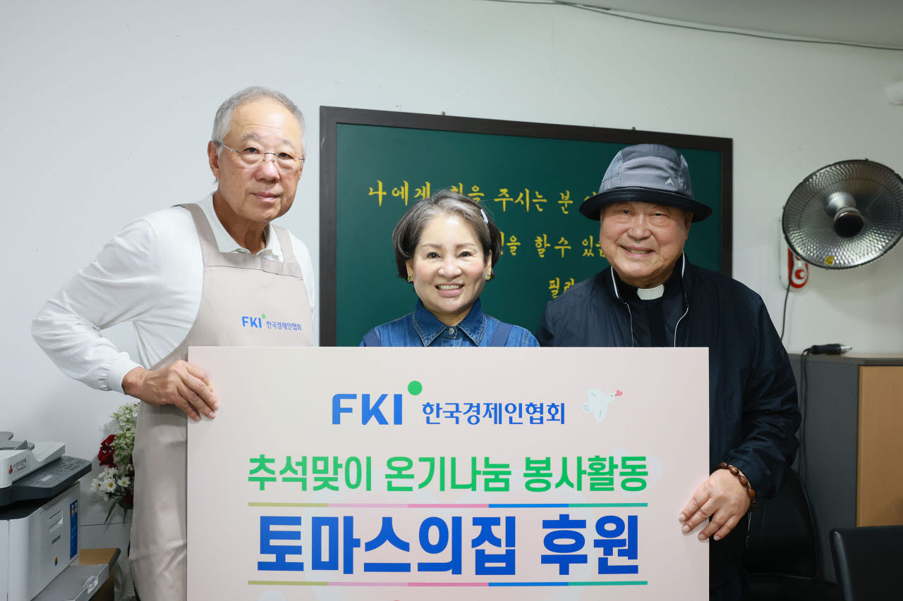 류진 한국경제인협회 회장(왼쪽)이 15일 영등포에 있는 무료급식소 '토마스의 집'을 찾아 김종국 토마스 아퀴나스 신부(오른쪽)에게 후원금을 전달한 뒤 기념촬영을 하고 있다. (사진=한경협)