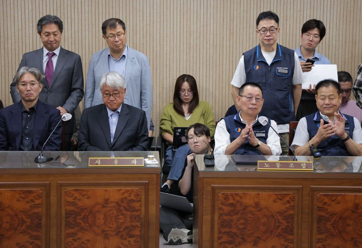 16일 서울 영등포구 서울지방노동위원회에서 열린 버스노조의 노동 쟁의 관련 분쟁에 대한 조정 회의에서 박점곤 서울시버스노조 위원장이 조정안에 서명한 뒤 박수를 치고 있다.(사진=연합뉴스)