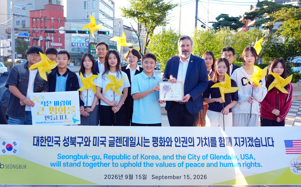 15일 성북천 한·중 평화의 소녀상을 방문한 이승로 성북구청장과 아디 카사키안 글렌데일시장이 성북구 청소년대표단과 기념사진을 찍고 있다. (사진=성북구)