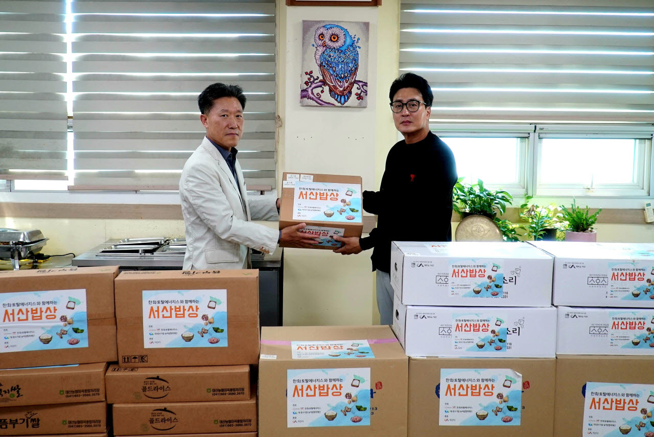 한화토탈에너지스 관계자(왼쪽)가 16일 고객사 ㈜대진을 방문해 정의석 대표이사에게 농수산물을 전달하고 있다. (사진=한화토탈에너지스)