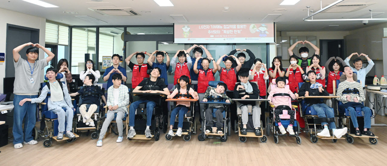 LG전자 '라이프스굿 봉사단' 인원들이 추석을 앞둔 지난 15일 염리장애인주간보호센터를 찾아 이용 장애인들이 함께 단체 사진을 찍고 있다. (사진=LG전자)