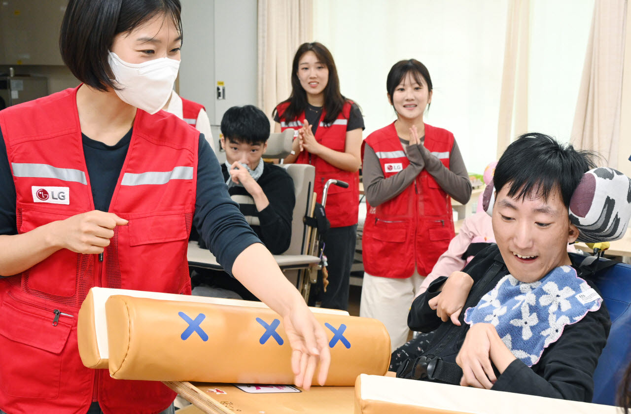 LG전자 '라이프스굿 봉사단' 인원들이 추석을 앞둔 지난 15일 염리장애인주간보호센터를 찾아 이용 장애인들과 함께 윷놀이를 하며 즐거운 시간을 보냈다. (사진=LG전자)
