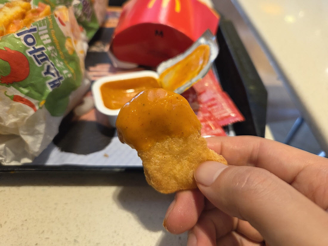 맥너겟에 고추장 버터 디핑소스를 찍어 먹는 모습. 소스는 짭짤하고 매콤한 맛 뒤로 은은한 고추장 향이 남았다. (사진=한전진 기자)