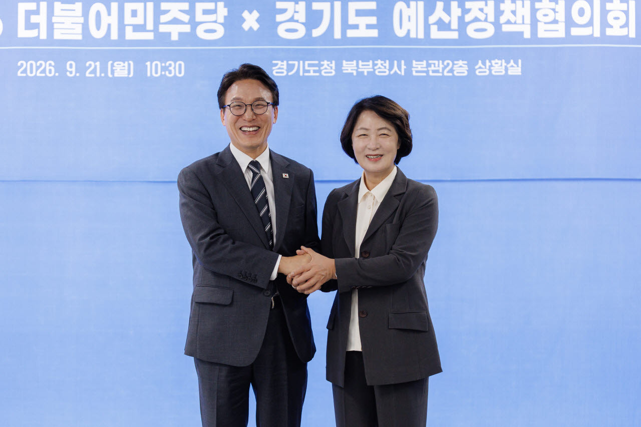 21일 의정부 경기도청 북부청사에서 열린 경기도-더불어민주당 예산정책협의회에서 추미애 경기도지사와 김민석 민주당 대표가 손을 잡고 기념사진을 찍고 있다.(사진=경기도)
